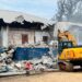 Excavator demolishes CDC headquarters building in Monrovia during court-ordered eviction operation.