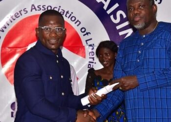 Christopher C. Walker shakes hands with Information Minister Jerelinmek Piah