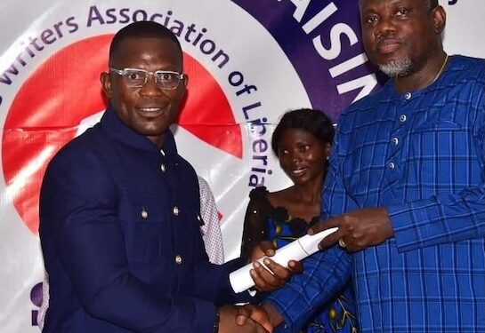 Christopher C. Walker shakes hands with Information Minister Jerelinmek Piah