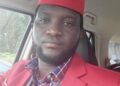 Former Liberian footballer Emmanuel Wennah in a red suit and cap, preparing to launch the Play With Purpose sports reform initiative
