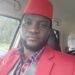 Former Liberian footballer Emmanuel Wennah in a red suit and cap, preparing to launch the Play With Purpose sports reform initiative