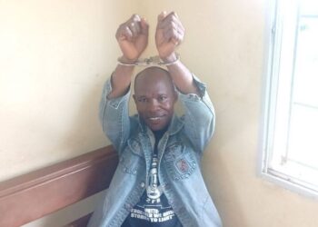 Liberian journalist Eric Opa Doue in handcuffs raising his hands, following a second attempted arrest in River Cess County