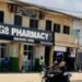 G-2 Pharmacy storefront in Monrovia, Liberia, with a commercial motorcyclist passing by on the main street in front of the head office.