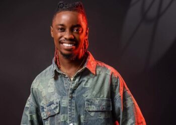 Liberian artist King Dennis smiles in a promo photo, symbolizing the power of Koloqua in building an authentic and global brand.