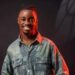 Liberian artist King Dennis smiles in a promo photo, symbolizing the power of Koloqua in building an authentic and global brand.