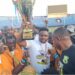 FC Fassell CEO and LFA presidential hopeful Cassell Kuoh celebrating with a trophy surrounded by supporters at a football stadium