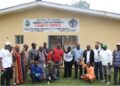 Officials and community members pose in front of the Liberia Land Authority County Office in Gbarnga following the successful resolution of a decades-old land dispute with LACRA.