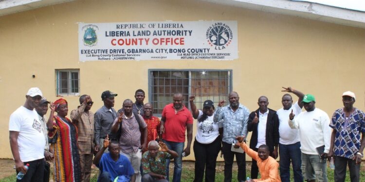 Officials and community members pose in front of the Liberia Land Authority County Office in Gbarnga following the successful resolution of a decades-old land dispute with LACRA.