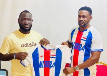 Mamadee Sheriff (left) receives the Nimba County football jersey from Alphanso Glaydor after being reappointed as head coach ahead of the 2025–26 County Sports Meet.