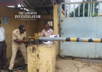 Court officers padlocking NEC premises during enforcement of a Commercial Court ruling in Monrovia.