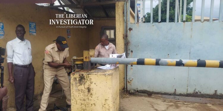 Court officers padlocking NEC premises during enforcement of a Commercial Court ruling in Monrovia.