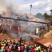 Crowds watch as smoke rises from a destroyed home and storage facility during a major fire in Pleebo City, Maryland County, Liberia
