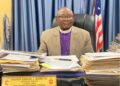 Bishop Samuel J. Quire Jr., Resident Bishop of the United Methodist Church in Liberia, seated at his desk addressing allegations linking the church to same-sex marriage