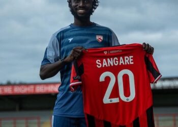 Liberian midfielder Mohammed Sangare holds his new Morecambe FC jersey after signing for the English National League side for the 2025-26 season