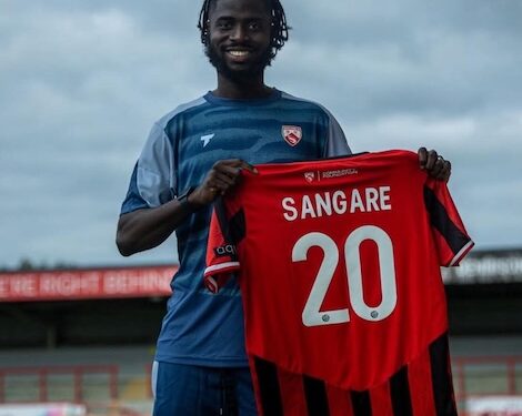Liberian midfielder Mohammed Sangare holds his new Morecambe FC jersey after signing for the English National League side for the 2025-26 season