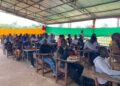 Over 100 Tubman University students seated in pavilion-turned-lecture hall as enrollment surge pushes administrators to expand learning spaces.