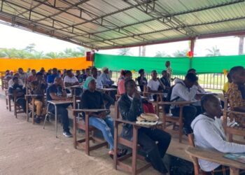 Over 100 Tubman University students seated in pavilion-turned-lecture hall as enrollment surge pushes administrators to expand learning spaces.