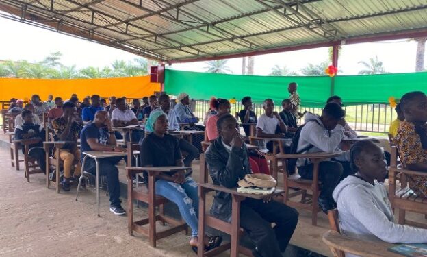Over 100 Tubman University students seated in pavilion-turned-lecture hall as enrollment surge pushes administrators to expand learning spaces.