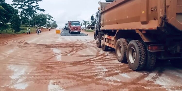 Construction trucks paving road in Tappita, Lower Nimba, Liberia