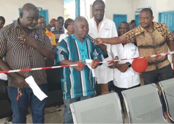 Local officials and healthcare workers cut ribbon during dedication of new outpatient department at Pleebo Health Center, Maryland County, Liberia.