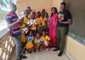 Sonia Harrison, CEO of the Fatimah Project, poses with ANSSA players after donating footballs in Monrovia.