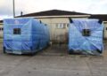 Two newly delivered high-capacity generators wrapped in protective blue covers at JFK Medical Center in Monrovia to end hospital power outages