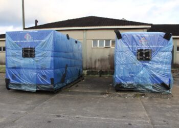 Two newly delivered high-capacity generators wrapped in protective blue covers at JFK Medical Center in Monrovia to end hospital power outages