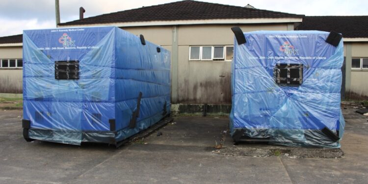Two newly delivered high-capacity generators wrapped in protective blue covers at JFK Medical Center in Monrovia to end hospital power outages