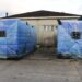 Two newly delivered high-capacity generators wrapped in protective blue covers at JFK Medical Center in Monrovia to end hospital power outages