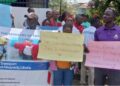 Transport Ministry staff protest in Monrovia holding placards against the Liberia Traffic Management Incorporated concession deal