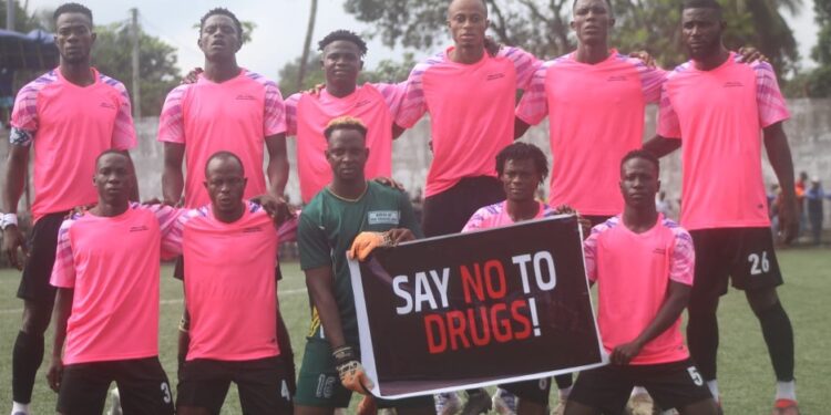 Liberia football team holding a “Say No to Drugs” sign before a match, promoting LFA’s upcoming mandatory drug testing policy