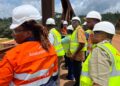 Liberian lawmakers and ArcelorMittal officials wearing safety gear during an oversight visit to inspect concession compliance under the Mineral Development Agreement