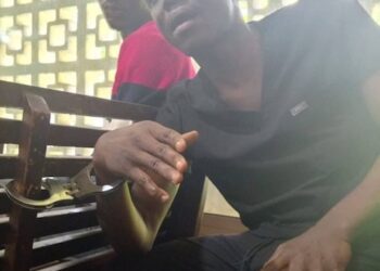 Bill Peters, TNIMA student and whistleblower, seated in custody after his arrest in Monrovia.