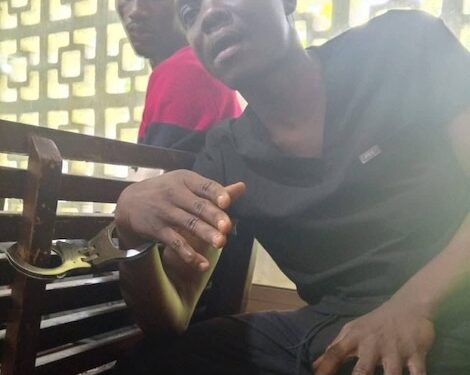 Bill Peters, TNIMA student and whistleblower, seated in custody after his arrest in Monrovia.