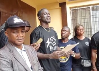 Anti-drug campaigners in black attire present a petition to Bong County authorities in Gbarnga, demanding tougher action against drug trafficking and abuse