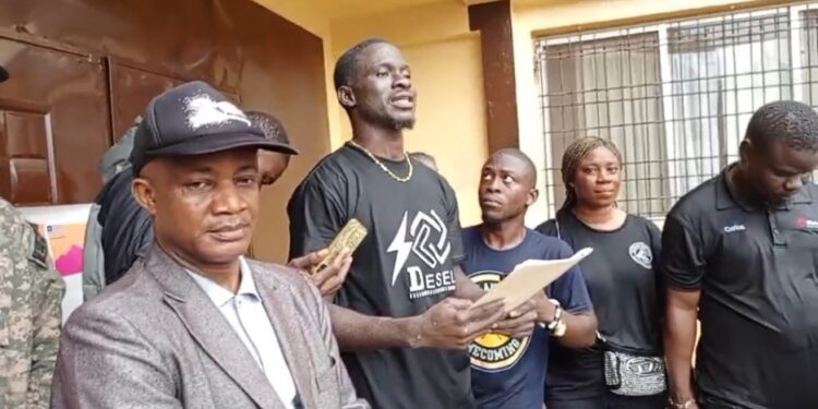 Anti-drug campaigners in black attire present a petition to Bong County authorities in Gbarnga, demanding tougher action against drug trafficking and abuse