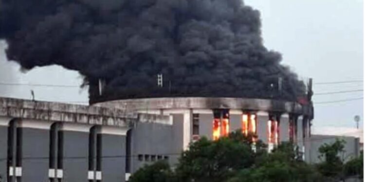 Thick black smoke and flames rise from the Liberian Capitol Building during the arson attack at the center of a high-profile trial over evidence suppression.