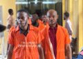 Defendants in orange prison uniforms escorted to court during the Capitol Building arson case in Monrovia