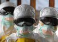 Liberian health workers in full protective gear during Ebola response, as the Health Ministry issues an alert and quarantines contacts after a suspected Ebola death.