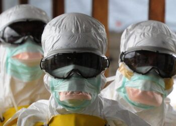 Liberian health workers in full protective gear during Ebola response, as the Health Ministry issues an alert and quarantines contacts after a suspected Ebola death.