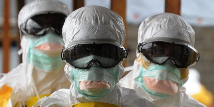 Liberian health workers in full protective gear during Ebola response, as the Health Ministry issues an alert and quarantines contacts after a suspected Ebola death.