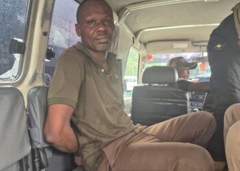 Ecobank robbery suspect Fobay Emery Johnson seated inside a police vehicle in Monrovia, accused of armed robbery and citing mental illness in court.