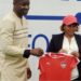 LFA President Mustapha Raji and women’s national team coach Selam Kebede hold a Liberia jersey during her unveiling as contract renewal talks begin