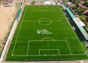 Aerial view of Liberia Football Association’s new FIFA-approved football pitch in Gompa, Nimba County, featuring lush green turf, lined markings, and spectator stands.