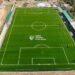 Aerial view of Liberia Football Association’s new FIFA-approved football pitch in Gompa, Nimba County, featuring lush green turf, lined markings, and spectator stands.