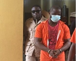 Accused Lawrence K. Williams in prison uniforms escorted by officers at the Temple of Justice