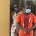 Accused Lawrence K. Williams in prison uniforms escorted by officers at the Temple of Justice