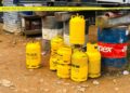 Yellow Mira Gas cylinders stacked near drums inside a restricted area in Monrovia after explosion incident.