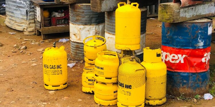 Yellow Mira Gas cylinders stacked near drums inside a restricted area in Monrovia after explosion incident.