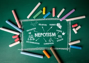 green board with nepotism written on it and chalks of different colors